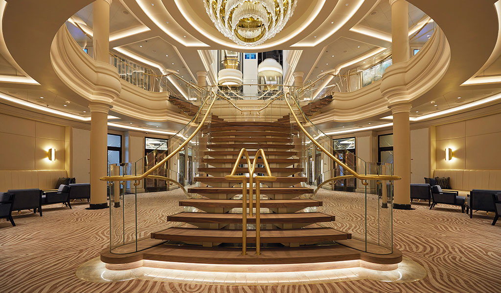 wooden staircase with a grand chandelier in atrium on Seven Seas Splendor